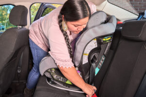 Person installing a car seat in a passenger vehicle