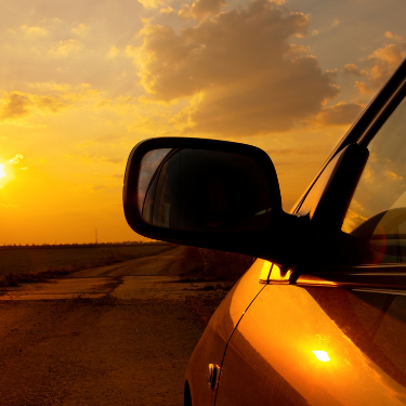 This is a photo of a hot sun shining down on a parked car.